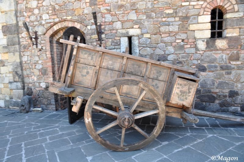 Деревянная телега у каменной стены Castello Di Amorosa